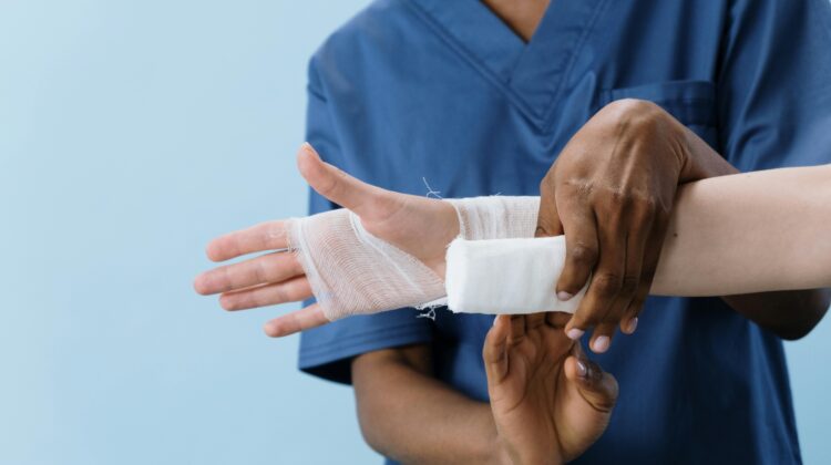 Avoid personal injury claim mistakes in Douglasville, GA. Image of doctor wrapping patient's wrist.